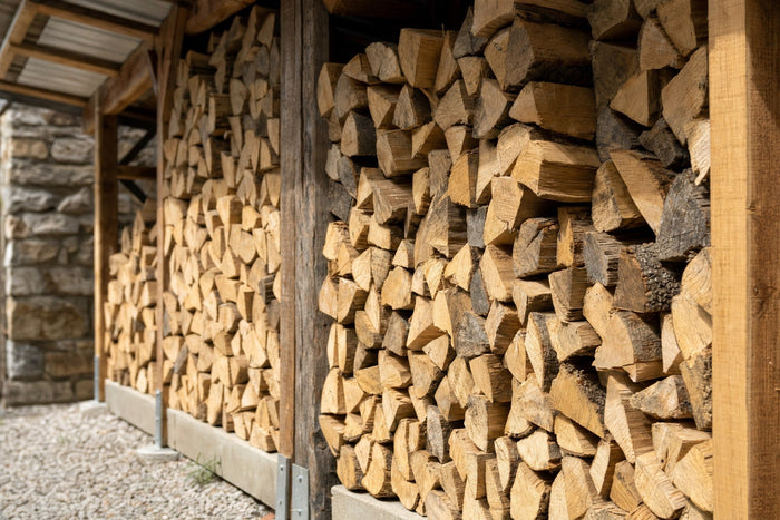 Gestapeltes Kaminholz aus gespaltenen Buchenscheiten in einem überdachten Lager
